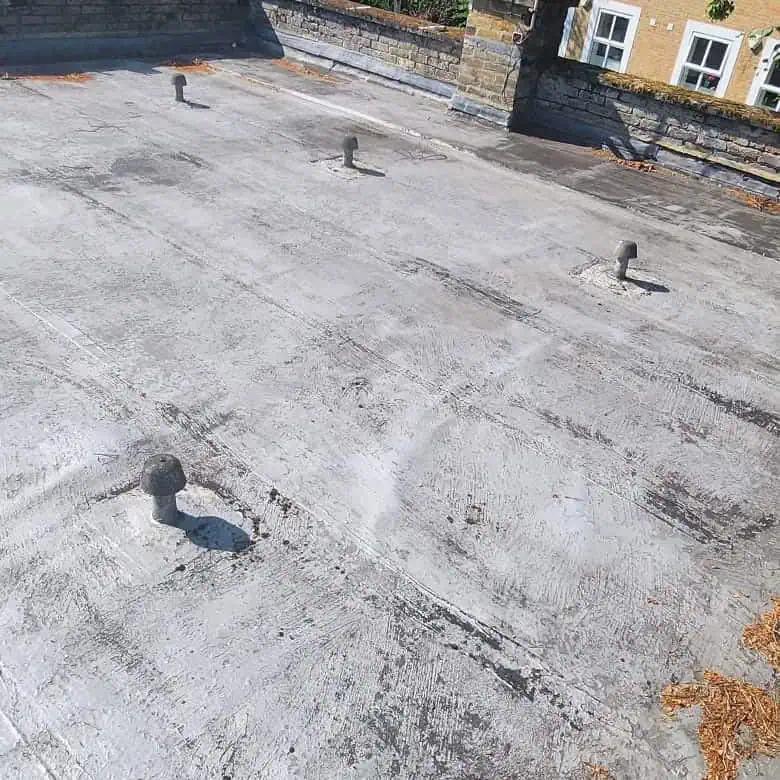 Worn silver-coated felt flat roof in Weybridge before repair