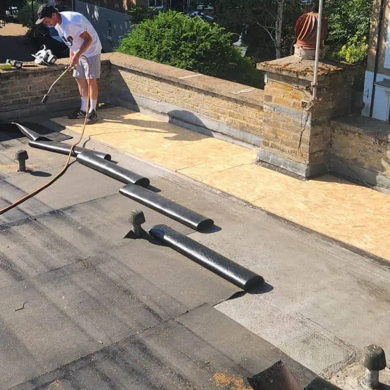Roofer torching on new felt to a flat roof in Weybridge